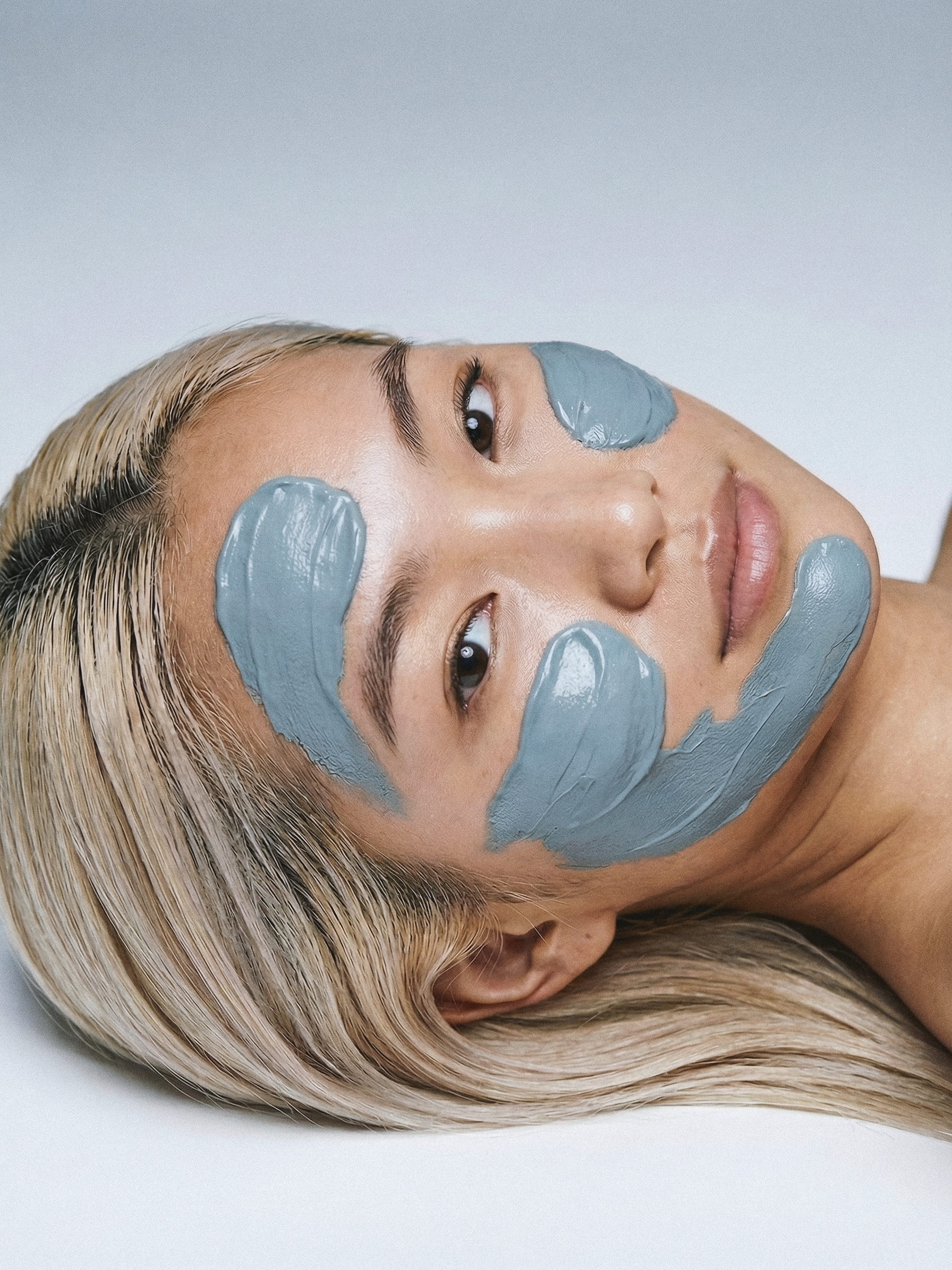 Unisex beauty campaign photography and premium launch imagery showcasing a male model applying a mineral clay mask for a skincare brand