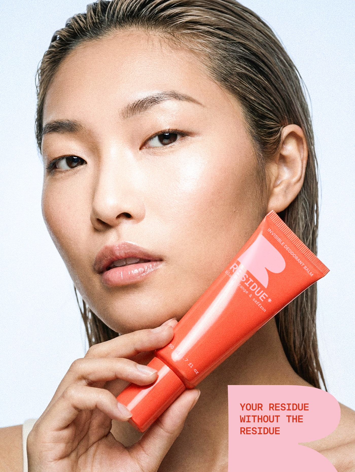Beauty campaign and packaging layout showcasing a model holding the Residue orange deodorant tube